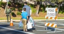 After being evacuated due to the Silverado Fire, a family walks with their belongings along Rue de Valore back to their home in Foothill Ranch moments after the evacuation orders were lifted, but the roads were still closed, Wednesday, Oct. 28, 2020. (Mark Rightmire/The Orange County Register via AP)