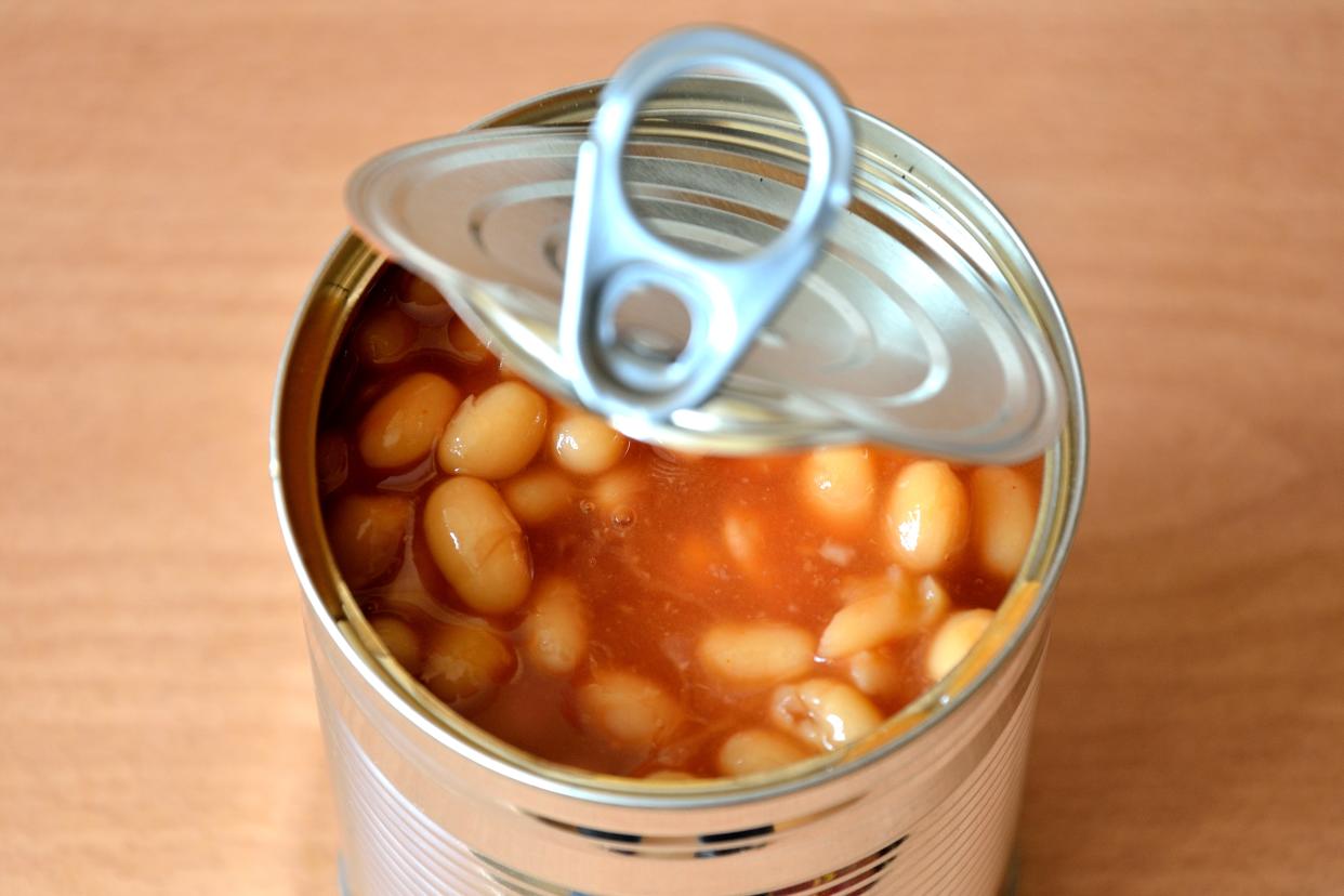 A selective focus image of tin of baked beans open on the work top.