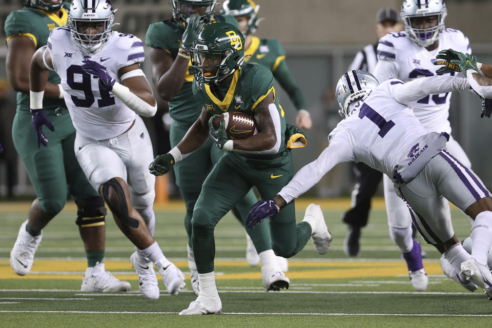 Baylor running back Richard Reese (29) breaks through a tackle of Kansas State safety Josh Hayes (1) in the first half of an NCAA college football game, Saturday, Nov. 12, 2022, in Waco, Texas. (AP Photo/Jerry Larson)