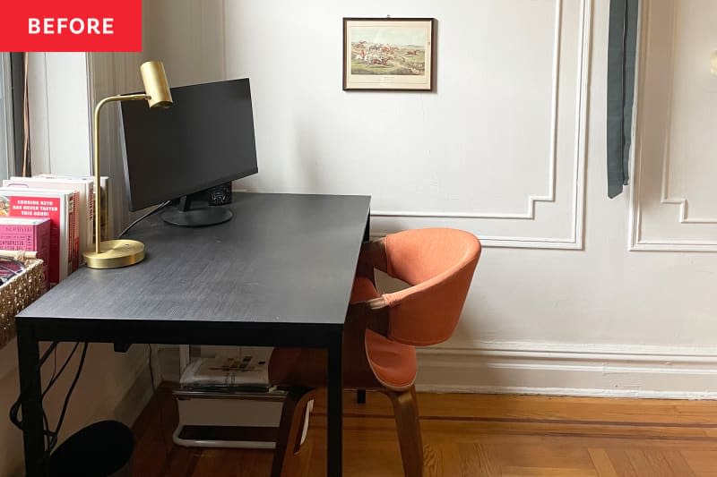 Computer monitor on dark wood table/desk with orange chair in room with art hung on neutral walls with decorative moulding.