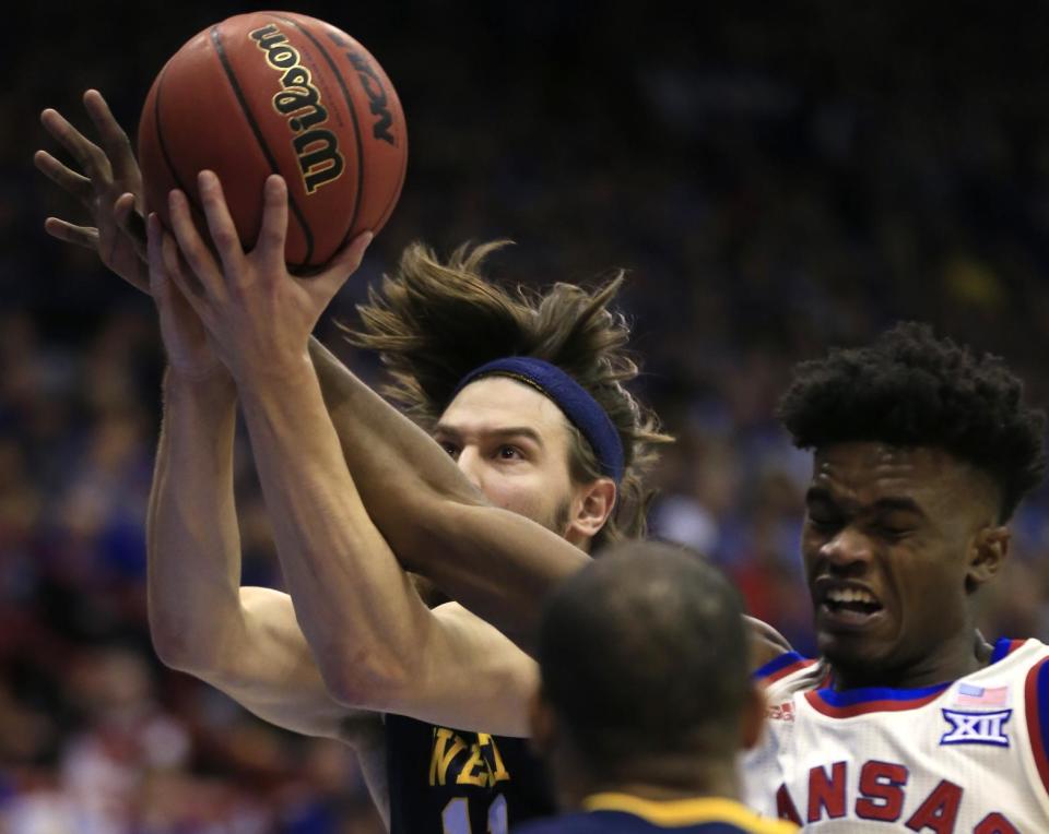 West Virginia forward Nathan Adrian (11) rebounds against Kansas guard Lagerald Vick, right, during the first half of an NCAA college basketball game in Lawrence, Kan., Monday, Feb. 13, 2017. (AP Photo/Orlin Wagner)