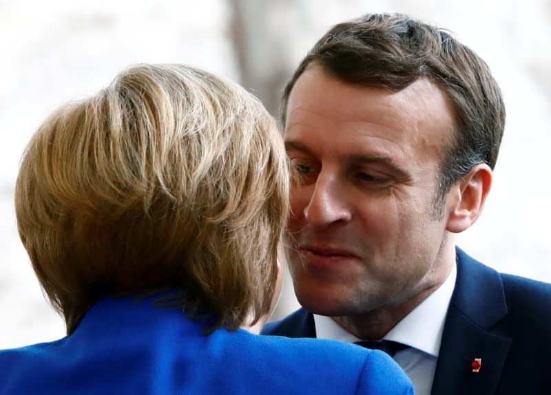 German Chancellor Angela Merkel welcomes French President Emmanuel Macron at the Libya summit in Berlin