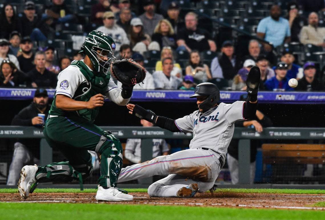 Miami Marlins first baseman Yuli Gurriel (10) slides in at home scoring as Colorado Rockies catcher Elias Diaz (35) receives the throw late in the sixth inning at Coors Field on Wednesday, May 24, 2023. John Leyba/USA TODAY Sports