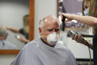 Gov. Tim Walz gets his hair cut by Erin Diede as he stopped in the morning at Capitol Barbers in the Minnesota State Office Building, Friday, June 5, 2020, in St. Paul, Minn. Walz went for a haircut and then toured some of the sites where vandalism occurred during the George Floyd protests. (Anthony Souffle/Star Tribune via AP)