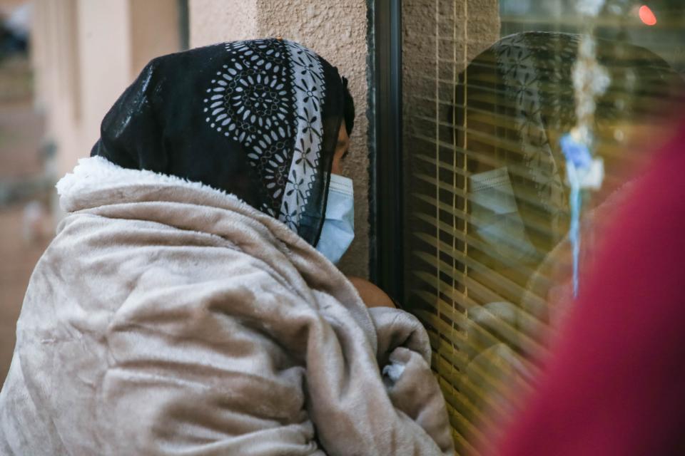 Genoveva Garcia looks through a Memorial Medical Center window at her husband, Jose Garcia, 68, who is being treated for COVID-19 on Monday, Nov. 30, 2020, in Las Cruces, New Mexico.
