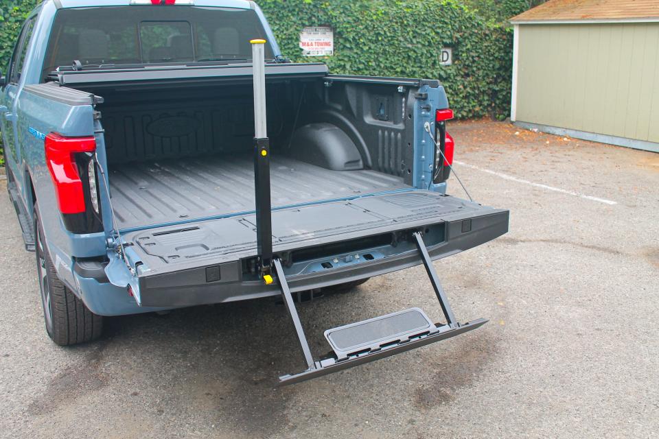 The bed of the 2023 Ford F-150 Lightning Platinum, with a built-in step engaged.