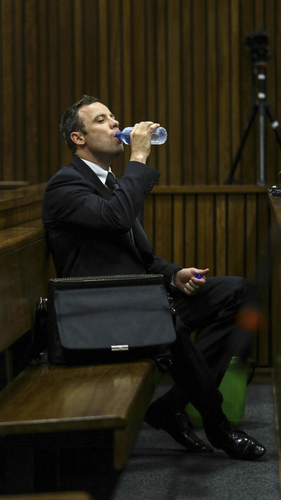 Oscar Pistorius sips water in the dock while listening to cross questioning about the events surrounding the shooting death of his girlfriend Reeva Steenkamp, in court during the second week of his trial in Pretoria, South Africa, Tuesday, March 11, 2014. Pistorius is charged with the shooting death of Steenkamp, on Valentines Day in 2013. (AP Photo/Kevin Sutherland, Pool)