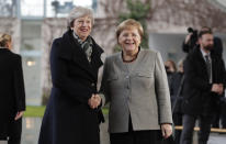 German Chancellor Angela Merkel, right, welcomes British Prime Minister Theresa May prior to a meeting in the chancellery in Berlin, Germany, Tuesday, Dec. 11, 2018. May is visiting several European countries to seek "assurances" on the Brexit agreement with the European Union to aid its passage through Britain's parliament. (AP Photo/Michael Sohn)