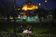 People break their fast after dusk on the first day of Ramadan backdropped by the iconic Byzantine-era Hagia Sophia mosque in Istanbul, Turkey, Thursday, March 23, 2023. Abstaining from all food and drink -- not even a sip of water is allowed-- and sexual intercourse from dawn to sunset during the Muslim holy month of Ramadan is regarded as an act of piety and devotion to God and an exercise in self-restraint. (AP Photo/Francisco Seco)