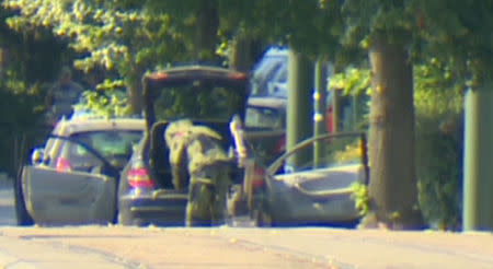 A bomb disposal expert is seen searching a car in the Brussels' commune of Woluwe St Pierre, June 30, 2018. RTL Television. TV Picture taken June 30, 2018. Reuters TV via REUTERS TV.
