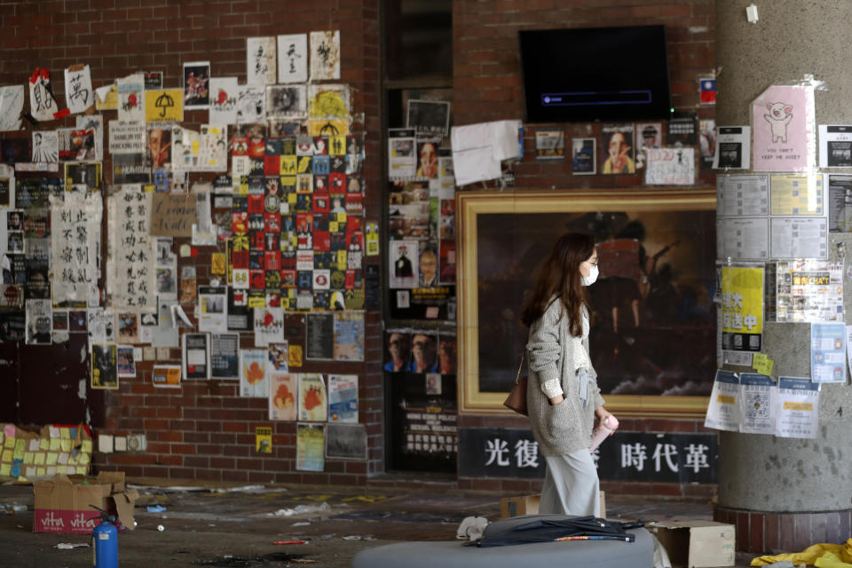 A woman walks through the campus of Hong Kong Polytechnic University in Hong Kong, Friday, Nov. 29, 2019. Hong Kong police were preparing Friday to reopen access to the university campus after blocking it for 12 days to try to arrest protesters holed up inside. (AP Photo/Vincent Thian)