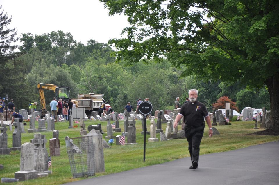Rev. G. David Weikart, pastor for St. Joseph's Catholic Church in Alliance, walks back from the exhumation of Kathryn Menendez's body on Tuesday, June 25, 2024, in St. Joseph's Cemetery in Alliance.