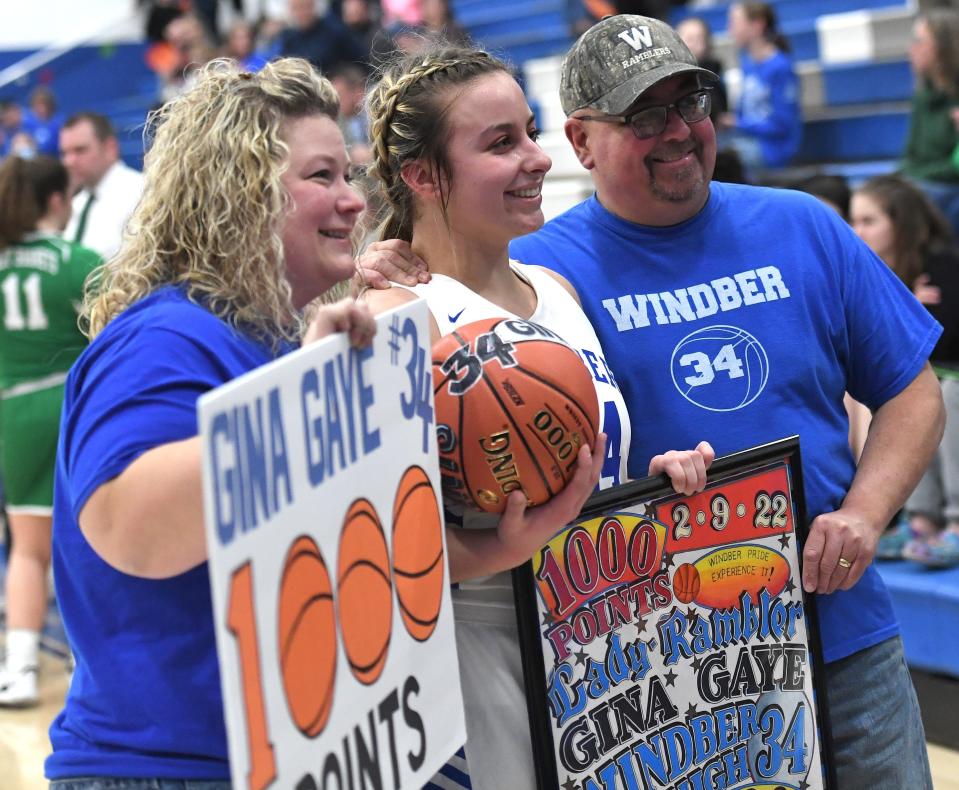 Windber senior Gina Gaye (center) poses with her parents, Lori and Glenn Gaye after reaching the 1,000-point mark for her career during the second quarter of a non-conference basketball game against Juniata Valley, Wednesday, in Windber.