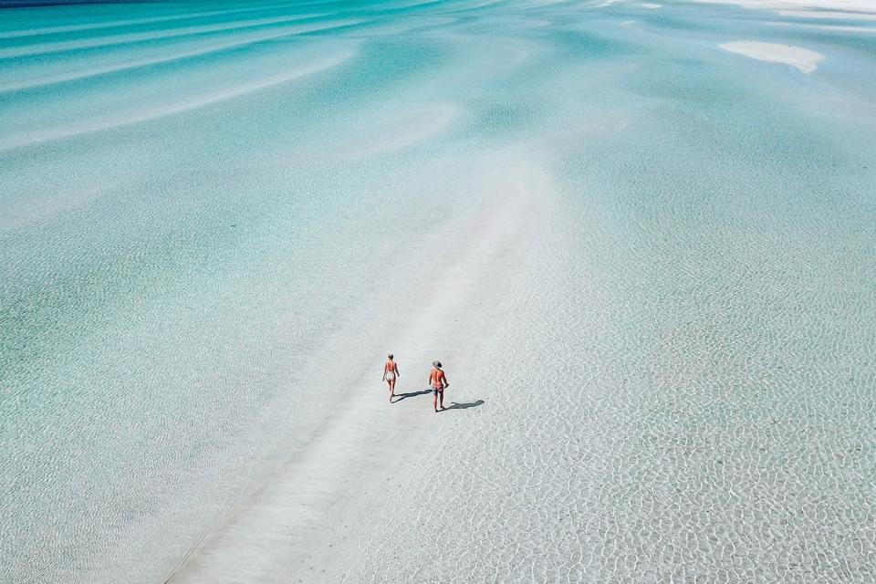 Two people walk through crystal clear water at Flaherty's Beach in South Australia. Source: Tourism Australia/via @_roamingaus_