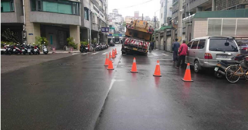 台中市南屯區三厝街路面塌陷，重達80噸的吊車卡在路中央，動彈不得。（圖／民眾提供）