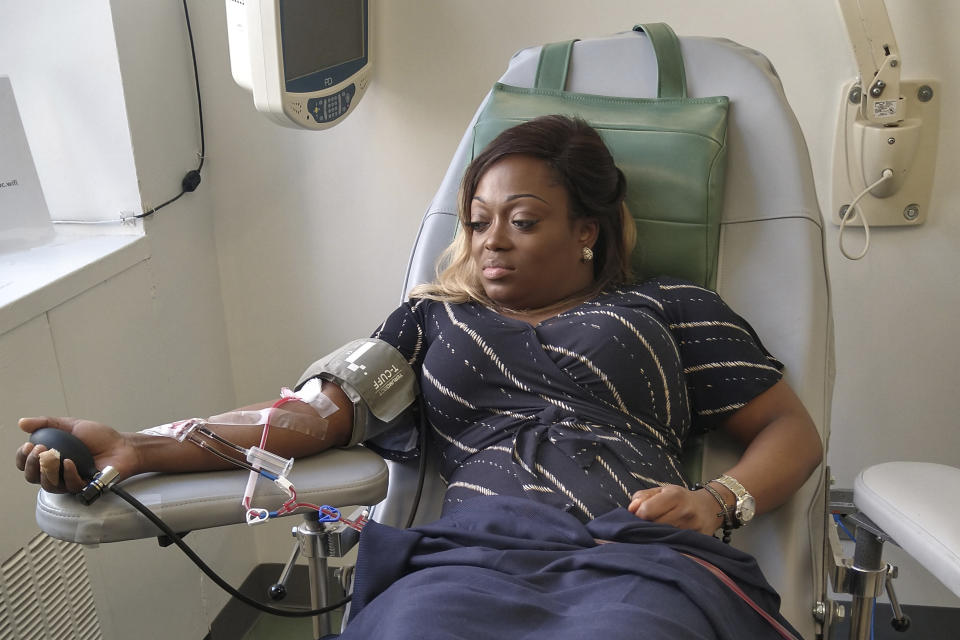 In this March 26, 2020 photo provided by Tiffany Pinckney, she donates blood for a study at a hospital in New York after recovering from COVID-19. “It is definitely overwhelming to know that in my blood, there may be answers,” said Pinckney, 39, (Courtesy Tiffany Pinckney via AP)