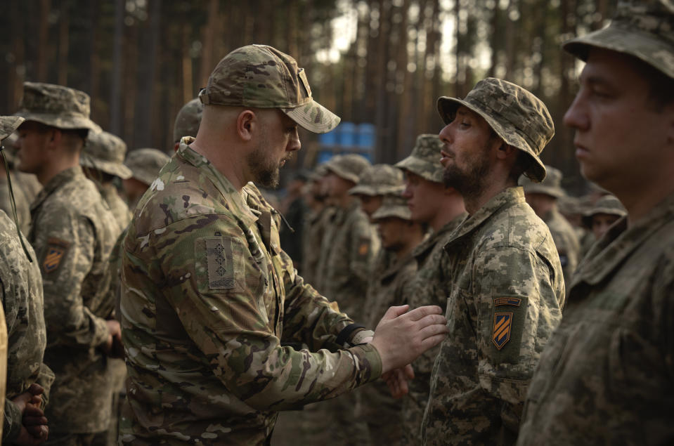 ARCHIVO - Soldados recién reclutados celebran el final de su instrucción en una base militar cerca de Kiev, Ucrania, el 25 de septiembre de 2023. Ucrania redujo el miércoles 3 de abril de 2024 la edad de reclutamiento de los 27 a los 25 años, en un intento de cubrir la falta de tropas para combatir a Rusia. (AP Foto/Efrem Lukatsky, Archivo)