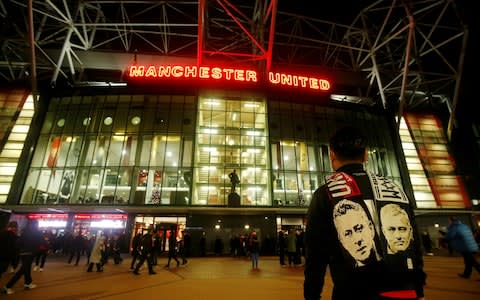 General view of a fan wearing a scarf bearing the faces of Tottenham Hotspur manager Jose Mourinho and Manchester United manager Ole Gunnar Solskjaer - Credit: Reuters