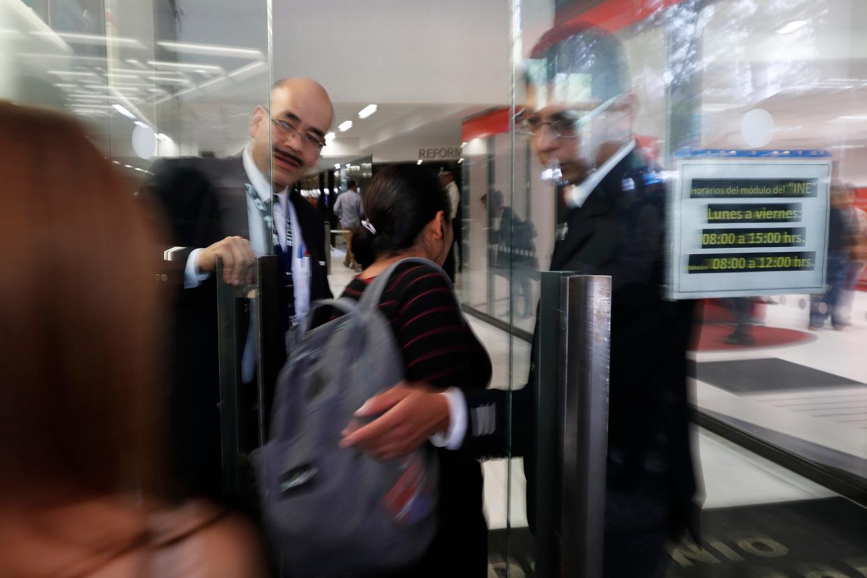 Security personnel guard the front door of a building that houses the federal mint's headquarters in Mexico City, Tuesday, Aug. 6, 2019.