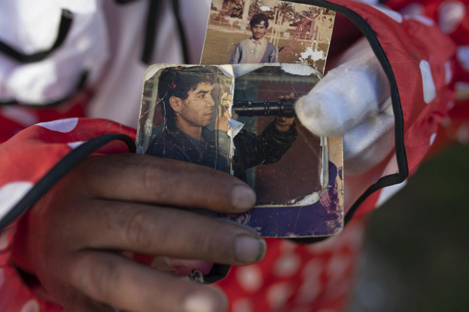 Belhussein Abdelsalam, a Charlie Chaplin impersonator, displays images of his younger self as a sports photographer in the 1980s, in Rabat, Morocco, Thursday, Dec. 31, 2020. When 58-year-old Moroccan Belhussein Abdelsalam was arrested and lost his job three decades ago, he saw Charlie Chaplin on television and in that moment decided upon a new career: impersonating the British actor and silent movie maker remembered for his Little Tramp character. (AP Photo/Mosa'ab Elshamy)