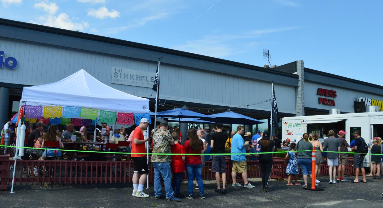 The line was long on June 14, 2021, as people waited for cicada food items, drinks and more outside the Sinkhole Craft Beer Bar in Bloomington during Cicada Mania. The Sinkhole will be partnering with All Creatures Yum once again, this time for Sinkhole De Mayo.