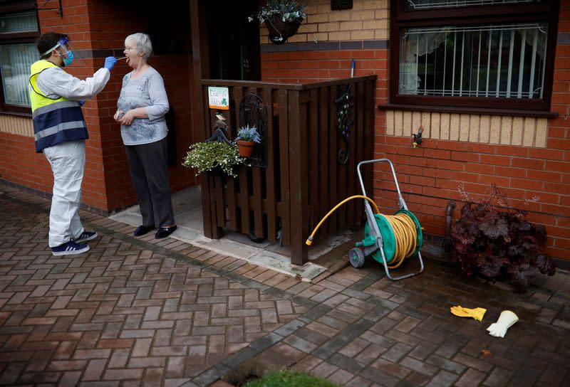 A member of the community swabbing team carries out a doorstep COVID-19 test following the outbreak of the coronavirus disease (COVID-19) in Chadderton, Britain