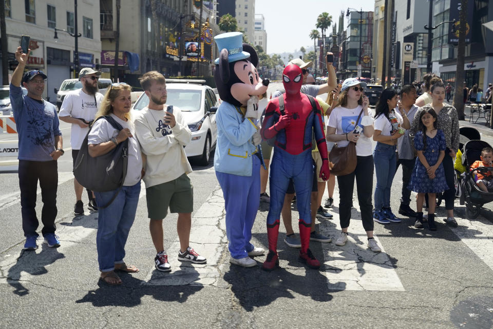 People along the motorcade route to a taping with Jimmy Kimmel Live! watch as President Joe Biden drives by prior to attending the Summit of the Americas, Wednesday, June 8, 2022, in Los Angeles. (AP Photo/Evan Vucci)