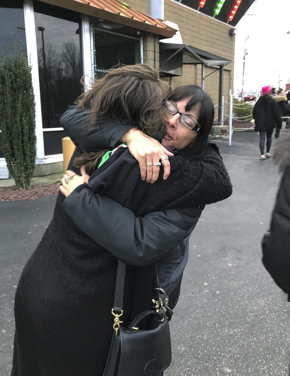 Tammy Marie Kruwell, right, hugs a coworker outside the Foxy strip club, Thursday, Dec. 20, 2018, in Providence, R.I. The city ordered the club to close on Wednesday. A city board voted to revoke its licenses after police charged three dancers with prostitution the previous week. (AP Photo/Michelle R. Smith)