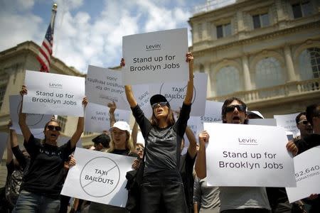 Uber riders and driver-partners take part in a rally on the steps of New York City Hall against proposed legislation limiting for-hire vehicles in New York June 30, 2015. REUTERS/Eduardo Munoz