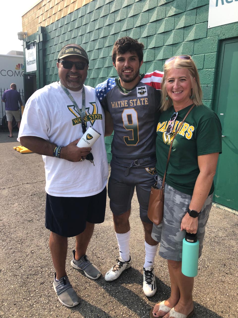 Brady Hessbrook poses with his father, Terry, and mother, Kristy, after a Wayne State football game.