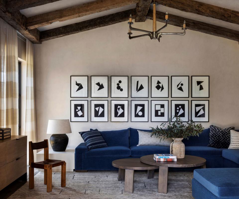 family room with blue sofas and round wooden coffee tables