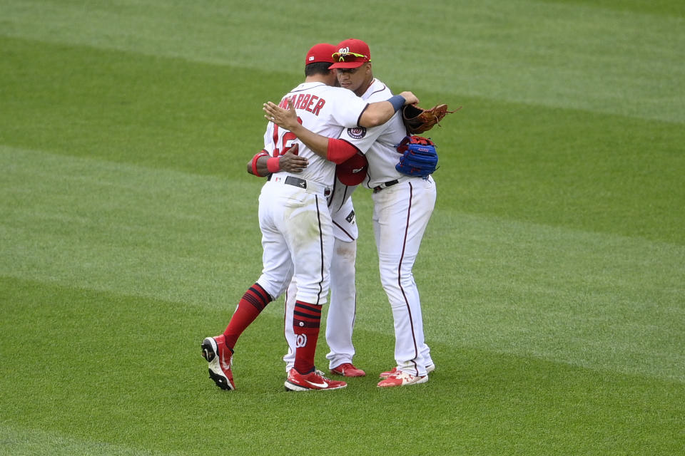 Washington Nationals left fielder Kyle Schwarber (12), Juan Soto, right, and Victor Robles, back center obscured, celebrate after a baseball game against the San Francisco Giants, Sunday, June 13, 2021, in Washington. The Nationals won 5-0. (AP Photo/Nick Wass)