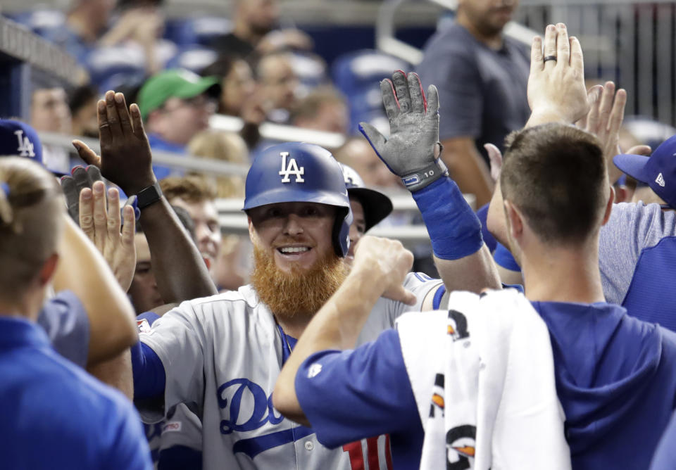 Los Angeles Dodgers' Justin Turner is congratulated in the dugout after hitting a two-run during the seventh inning of a baseball game against the Miami Marlins, Tuesday, Aug. 13, 2019, in Miami. (AP Photo/Lynne Sladky)