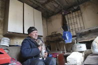 A man visits his home in the separatist-controlled territory to collect his cat after a recent shelling near a frontline outside Donetsk, eastern Ukraine, Friday, April 9, 2021. Tensions have built up in recent weeks in the area of the separatist conflict in eastern Ukraine, with violations of a cease-fire becoming increasingly frequent. (AP Photo)