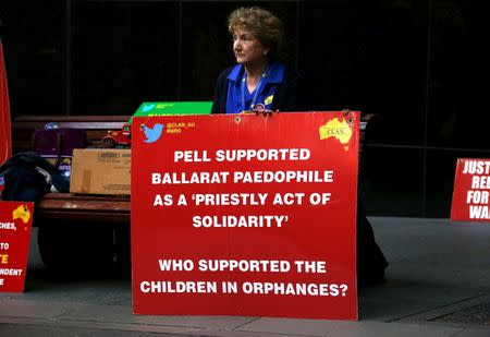 A relative of children who were sexually abused by the Catholic Church holds a placard as she sits outside the venue for Australia's Royal Commission into Institutional Response to Child Sexual Abuse in Sydney, Australia, February 29, 2016. REUTERS/David Gray