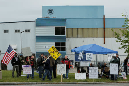 Locked-out members of the Local 651 International Brotherhood of Boilermakers union carry signs outside Westinghouse Electric's manufacturing facility in Newington, New Hampshire, U.S., May 22, 2017. REUTERS/Brian Snyder