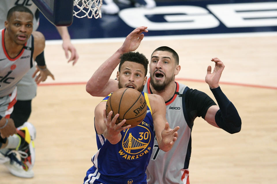 Golden State Warriors guard Stephen Curry (30) goes to the basket past Washington Wizards center Alex Len, back, during the second half of an NBA basketball game, Wednesday, April 21, 2021, in Washington. (AP Photo/Nick Wass)