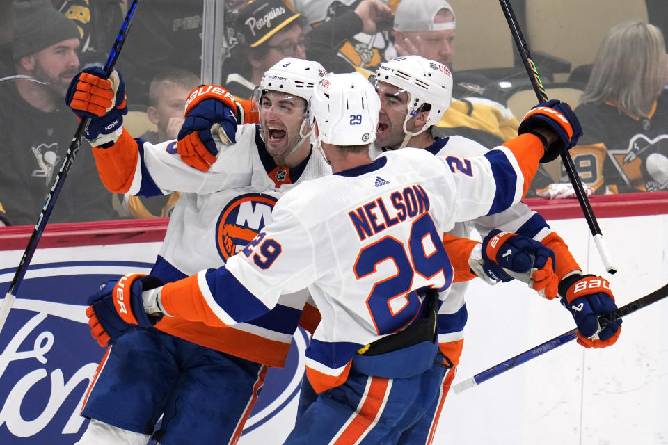 New York Islanders' Adam Pelech (3) celebrates his game-winning goal in overtime with Kyle Palmieri (21) and Brock Nelson during an NHL hockey game in Pittsburgh, Tuesday, Feb. 20, 2024. The Islanders won 5-4. (AP Photo/Gene J. Puskar)