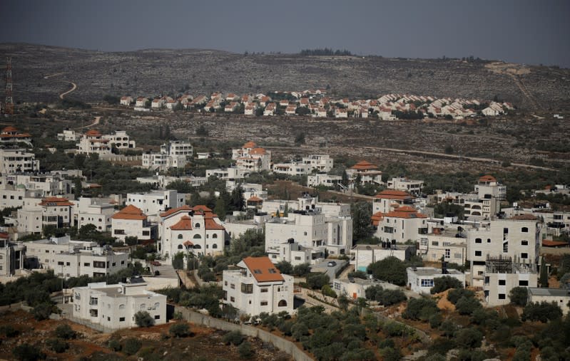 FILE PHOTO: A view shows Palestinian houses in the village of Ein Yabrud with the Jewish settlement of Ofra seen in the background, in the Israeli-occupied West Bank