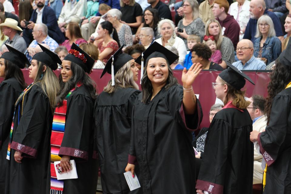 A graduate waves at her family Saturday at the WT Commencement Ceremony in Canyon.