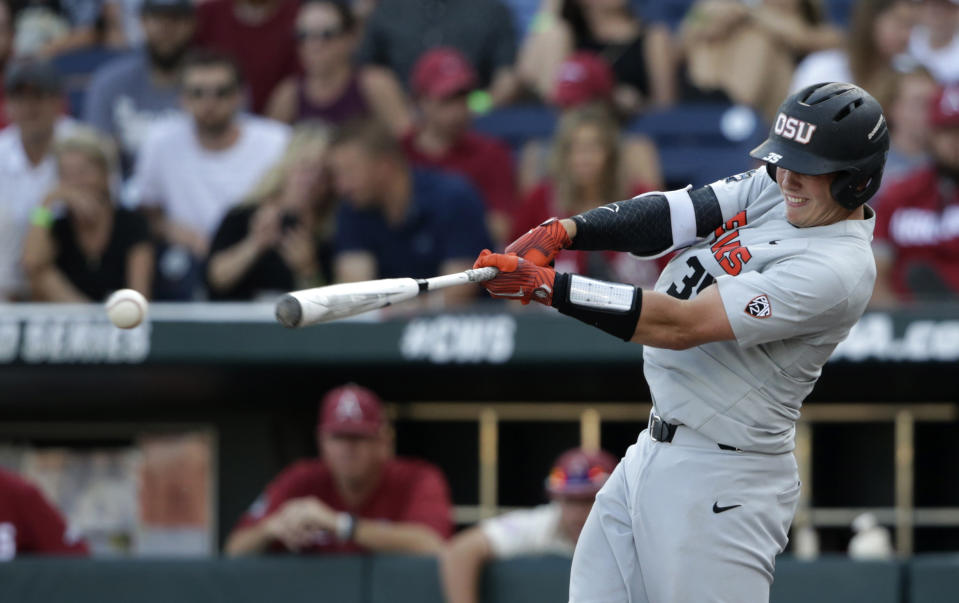 FILE - In this June 28, 2018, file photo, Oregon State's Adley Rutschman hits an RBI single to score Cadyn Grenier during the third inning of Game 3 against Arkansas in the NCAA College World Series baseball finals, in Omaha, Neb. The Baltimore Orioles lead off the Major League Baseball Draft for the first time in 30 years and Oregon State catcher Adley Rutschman is a heavy favorite to be selected No. 1 on Monday night, June 3, 2019. (AP Photo/Nati Harnik, File)