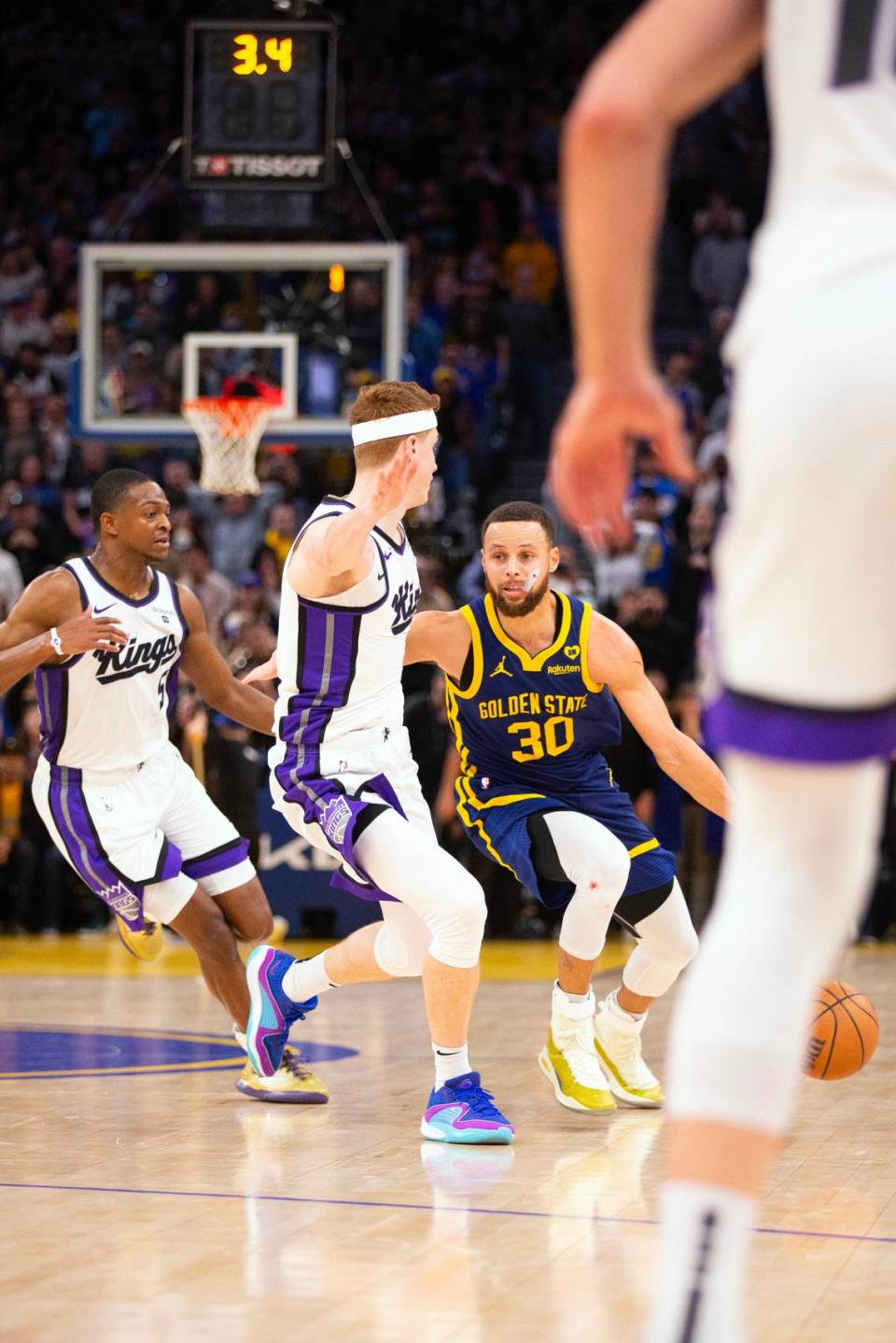 Golden State Warriors guard Stephen Curry (30) controls the ball against Sacramento Kings guards De’Aaron Fox (5) and Kevin Huerter (9) in the fourth quarter Thursday, Jan. 25, 2024, at Chase Center in San Francisco.
