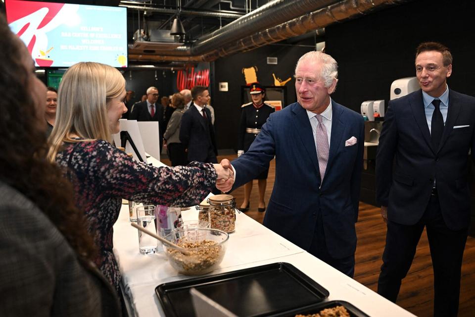 King Charles III (C) visits the kitchen inside the headquarters of cereal manufacturer Kellogg's marking its 100th anniversary in Manchester