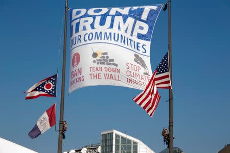 Female activists raise a banner from the flag poles outside the Rock and Roll Hall of Fame during the Republican National Convention in Cleveland. Reg Mizell/Handout via REUTERS