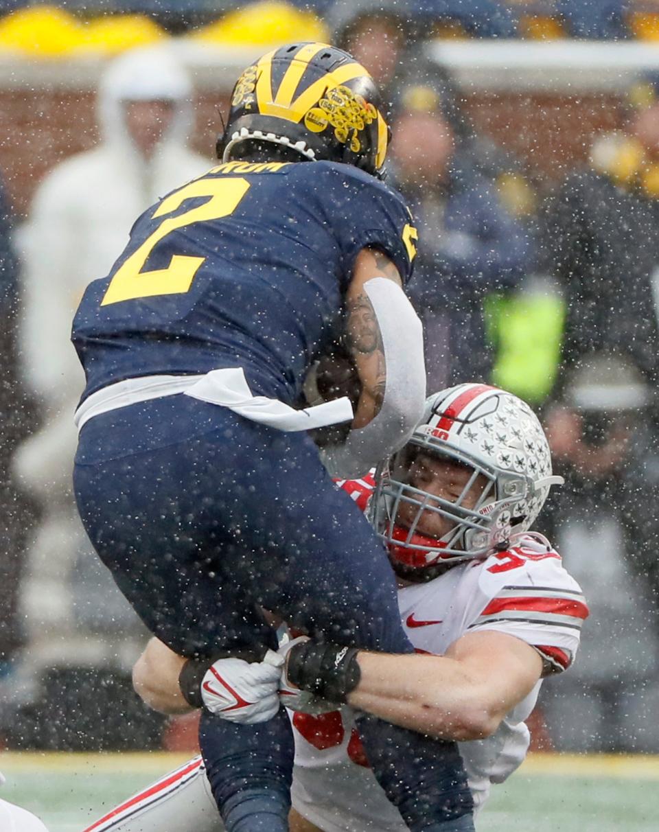 Ohio State linebacker Tommy Eichenberg tackles Michigan running back Blake Corum last year.