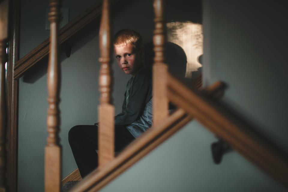 A little boy is sitting alone on the stairs