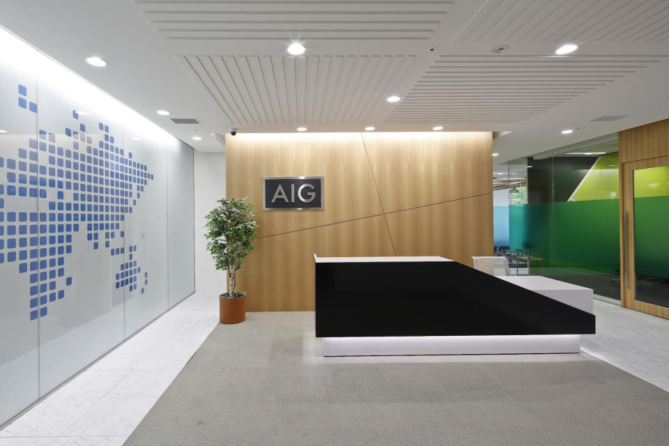 Office lobby with AIG logo on wood-paneled wall.