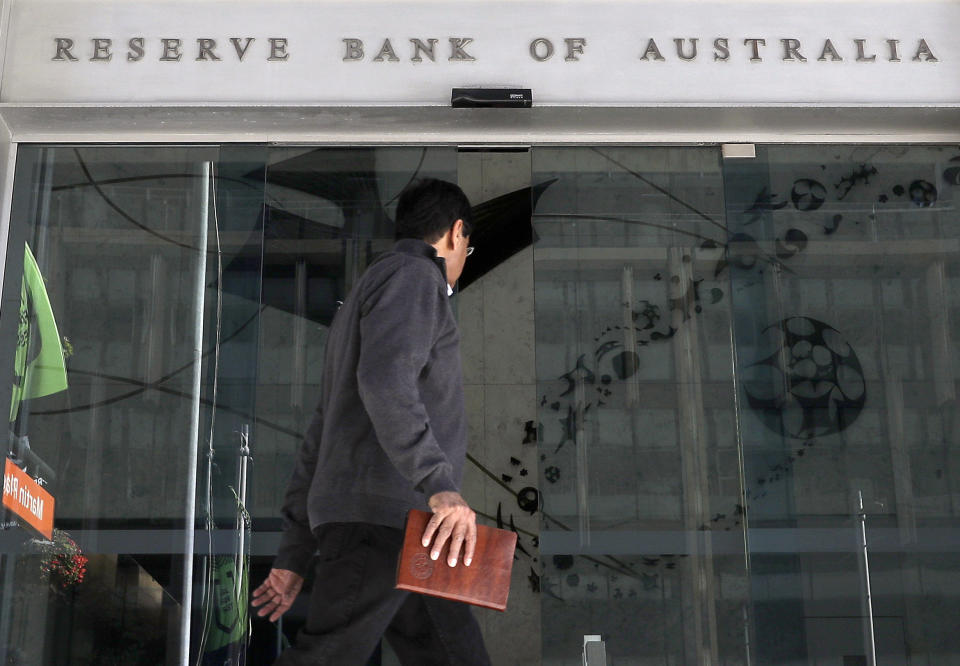 FILE - In this Oct. 1, 2019, file photo, a man walks past the Reserve Bank of Australia in Sydney. Australia’s central bank on Tuesday, March 3, 2020 cut its benchmark interest rate by a quarter of a percentage point to a record low of 0.5% in response to the economic shock of the new coronavirus. (AP Photo/Rick Rycroft, File)