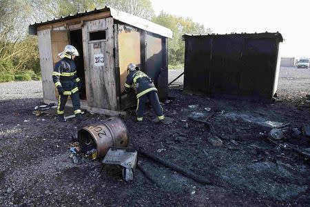 French firemen inspect a shelter the day after a fire destroyed large swathes of the Grande-Synthe migrant camp near Dunkirk in northern France April 11, 2017 following skirmishes on Monday that injured several people. REUTERS/Pascal Rossignol