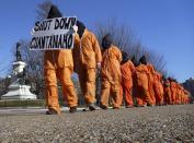 Members of the group "Witness Against Torture" dressed in orange prison jump suits protest against the detention camp at Guantanamo Bay, along Pennsylvania Avenue in Washington D.C. January 10, 2012. (REUTERS/Larry Downing)